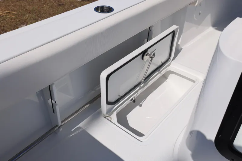 Slide: The Image of 2026 Sea Hunt Gamefish 25 boat storage compartment with open hatch and cup holder. - 15