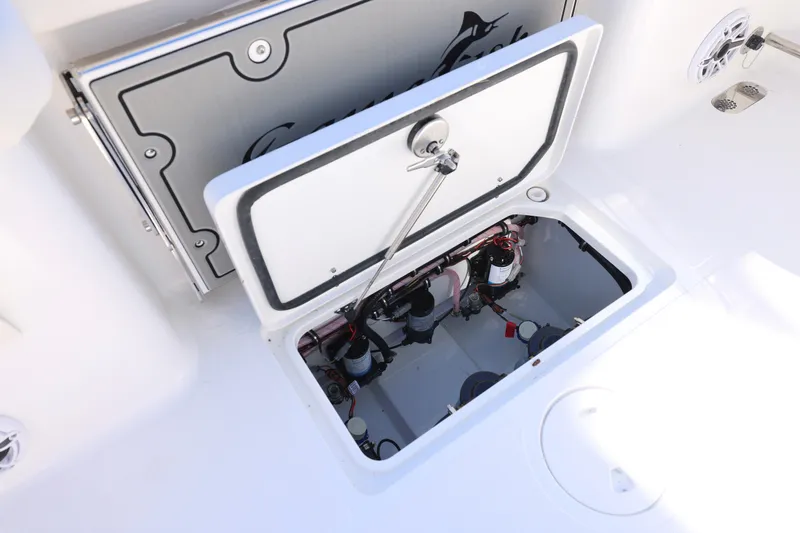 Slide: The Image of 2026 Sea Hunt Gamefish 25 boat storage compartment with open hatch and visible wiring. - 16