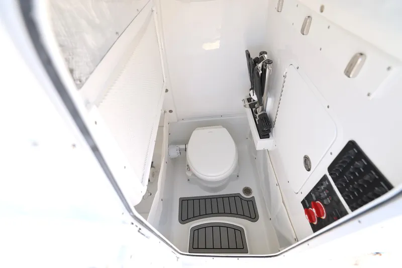 Slide: The Image of Interior of 2026 Sea Hunt Gamefish 25 boat, featuring a compact marine toilet. - 19