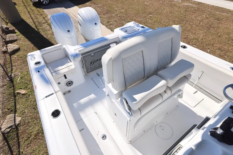 Slide: The Image of 2026 Sea Hunt Gamefish 25 boat interior with dual engines and cushioned seating. - 21