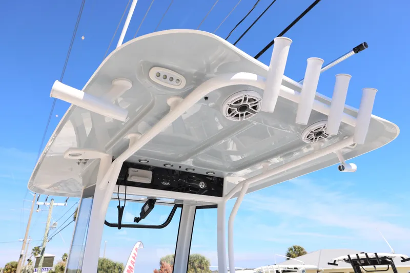 Slide: The Image of 2026 Sea Hunt Gamefish 25 T-top with rod holders and speakers against blue sky. - 6