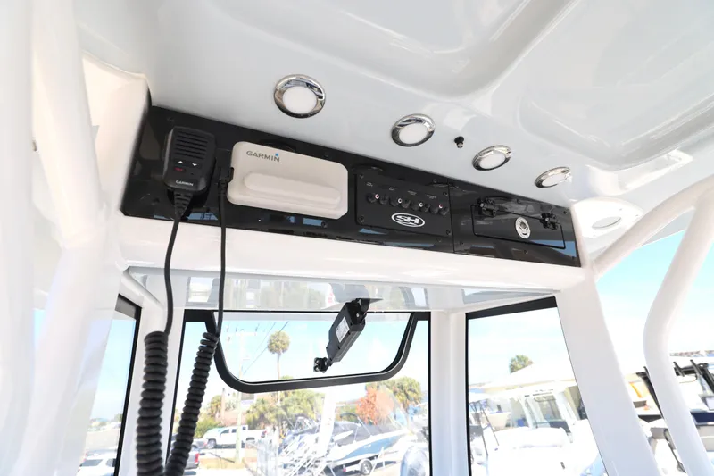 Slide: The Image of 2026 Sea Hunt Gamefish 25 boat console with Garmin electronics and overhead storage. - 9