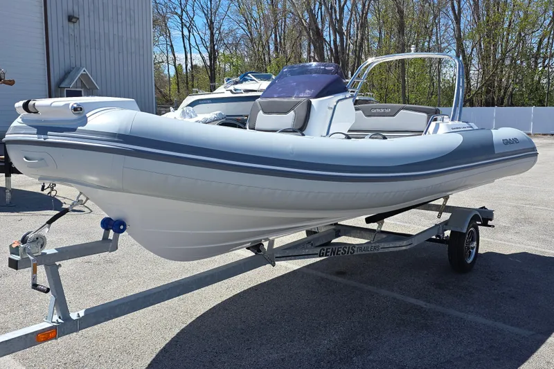 Slide: The Image of 2026 Grand Inflatables G500 boat on trailer, parked outdoors, showcasing sleek design. - 9