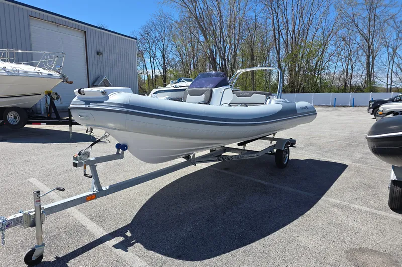 Slide: The Image of 2026 Grand Inflatables G500 boat on trailer in sunny parking lot. - 1
