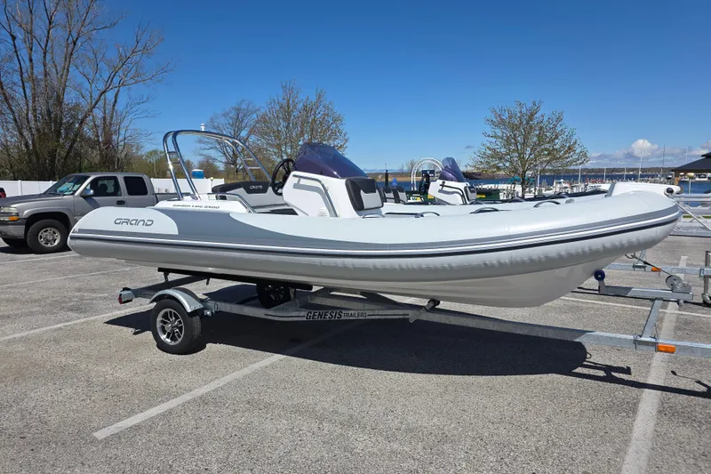 The Image of 2026 Grand Inflatables G500 boat on trailer in parking lot, clear sky background. - 0
