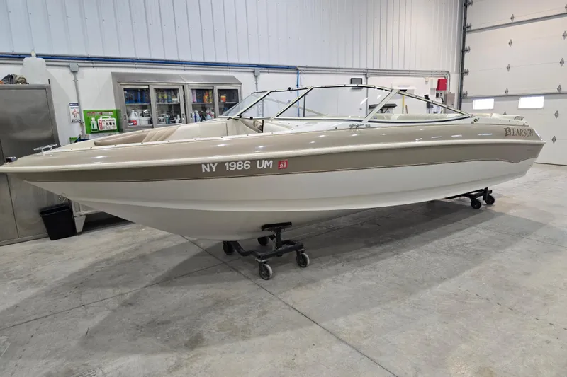 The Image of 1996 Larson LXi 218 boat in a garage, beige and white exterior. - 1