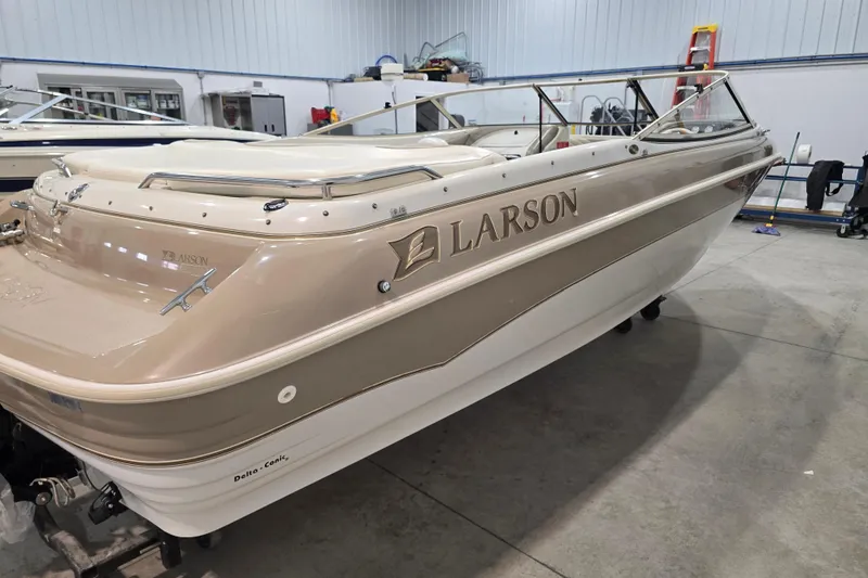 Slide: The Image of 1996 Larson LXi 218 boat in showroom, beige and white exterior, side view. - 10