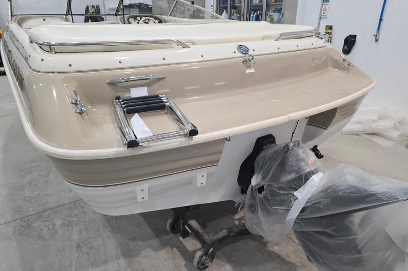 Slide: The Image of 1996 Larson LXi 218 boat in a garage, featuring a beige and white exterior. - 12