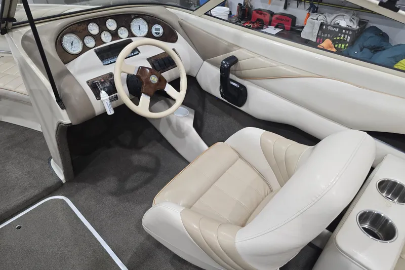 Slide: The Image of 1996 Larson LXi 218 boat interior with beige leather seats and dashboard controls. - 18
