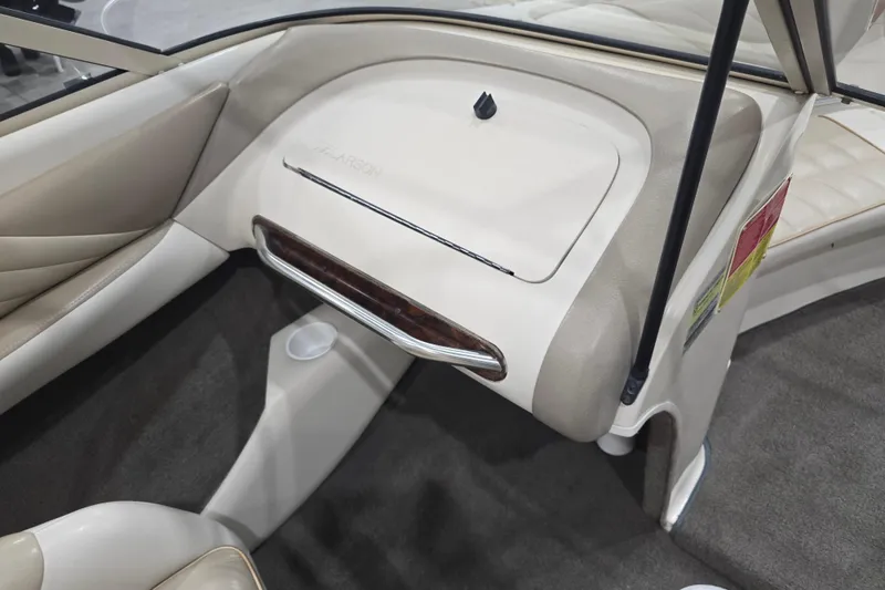 Slide: The Image of Interior of 1996 Larson LXi 218 boat, featuring beige upholstery and dashboard details. - 22