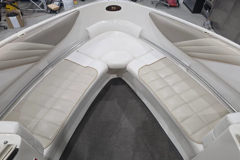 Slide: The Image of 1996 Larson LXi 218 boat interior with white cushioned seating and carpeted floor. - 23