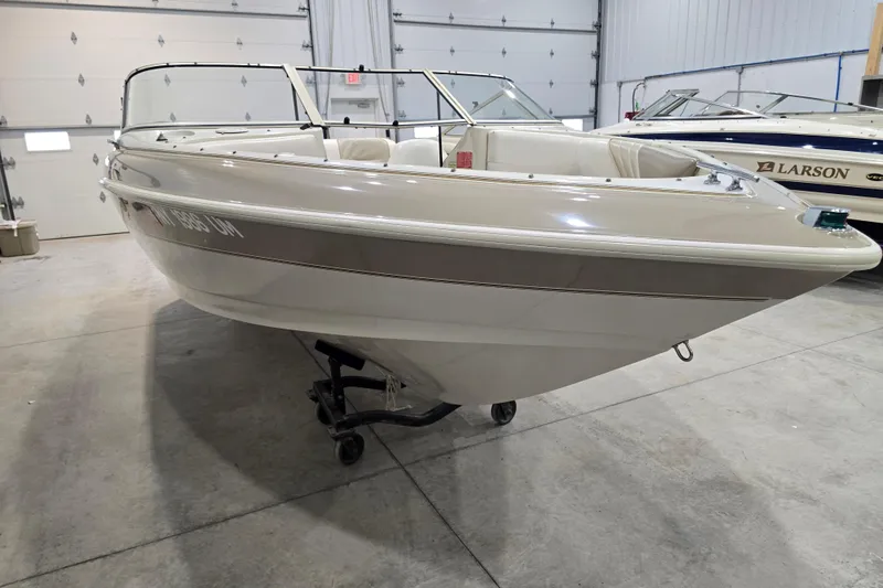 Slide: The Image of 1996 Larson LXi 218 boat in indoor storage, showcasing sleek design and white exterior. - 3