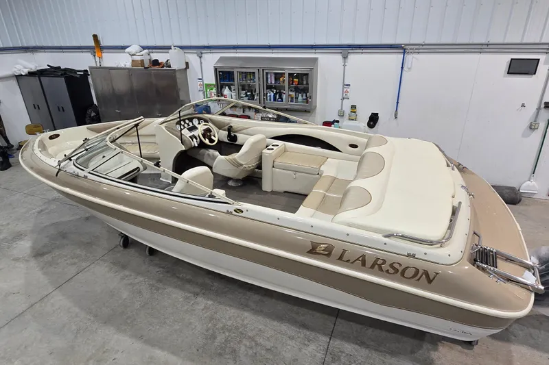 Slide: The Image of 1996 Larson LXi 218 boat in a garage, showcasing beige and white interior. - 38