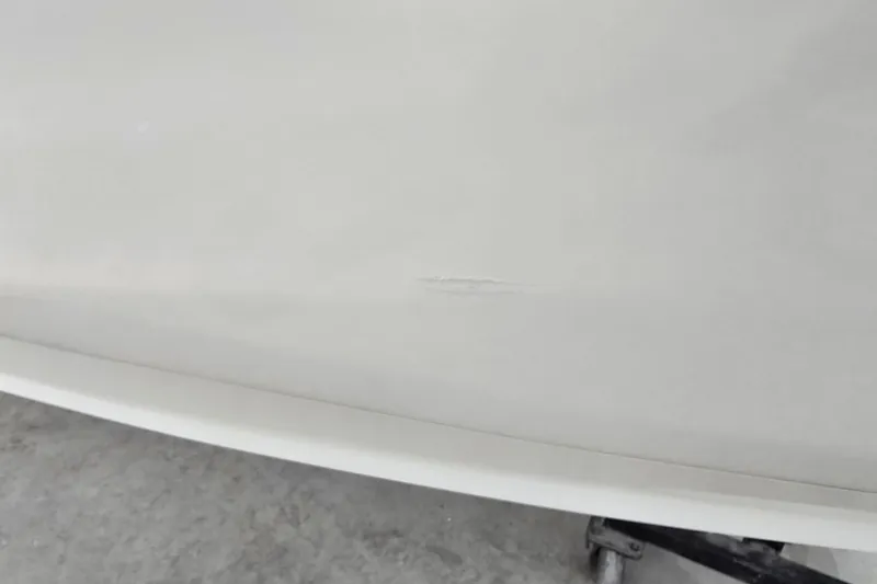 Slide: The Image of 1996 Larson LXi 218 boat hull with visible scratch on white surface. - 6