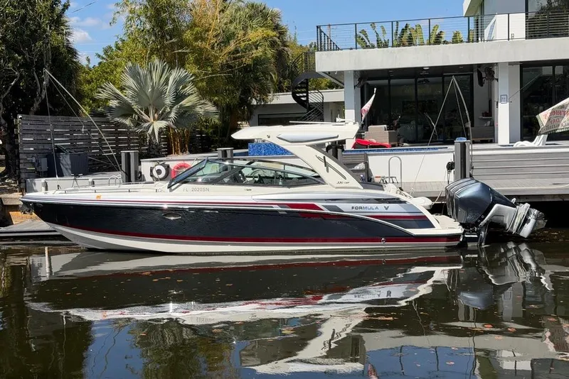 The Image of 2020 Formula 330 Crossover Bowrider OB docked by a modern waterfront home. - 1