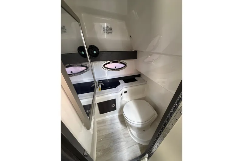 Slide: The Image of 2020 Formula 330 Crossover Bowrider OB bathroom interior with modern fixtures and porthole windows. - 21