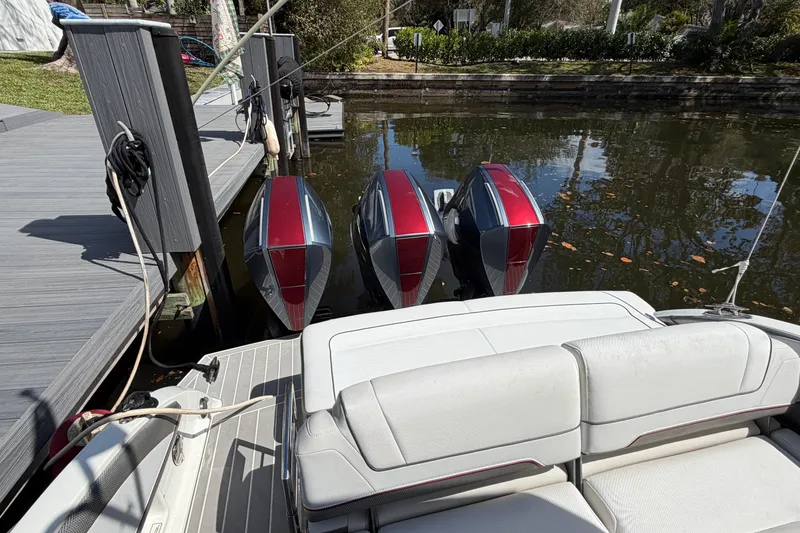 Slide: The Image of 2020 Formula 330 Crossover Bowrider OB with triple outboard engines docked by the water. - 4