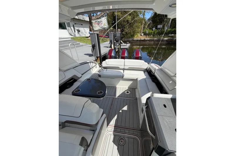 Slide: The Image of 2020 Formula 330 Crossover Bowrider OB interior with seating and table, docked by water. - 5
