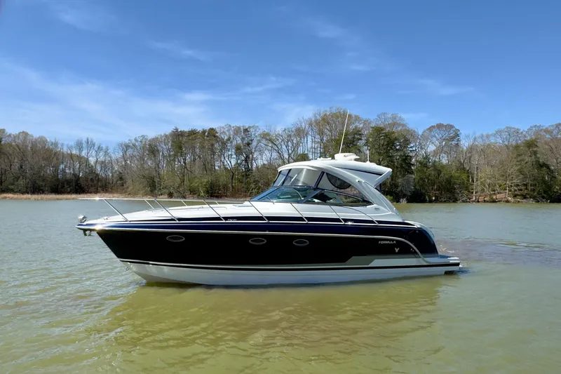 The Image of 2016 Formula 34 Performance Cruiser on a serene lake with forested shoreline. - 0