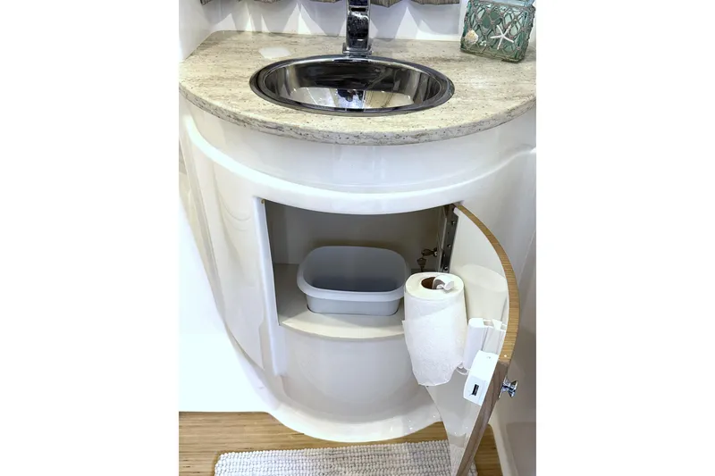 Slide: The Image of 2016 Formula 34 Performance Cruiser bathroom sink with storage cabinet open. - 34