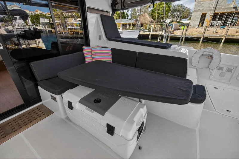 Slide: The Image of Outdoor seating area on a 2019 Lagoon 42 catamaran with cushions and a table. - 10