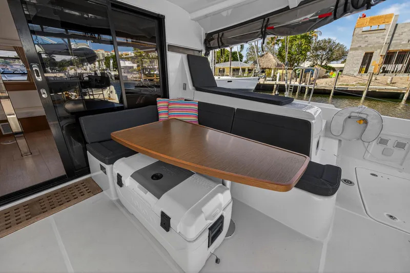 Slide: The Image of 2019 Lagoon 42 yacht cockpit with seating, table, and colorful pillow. - 16