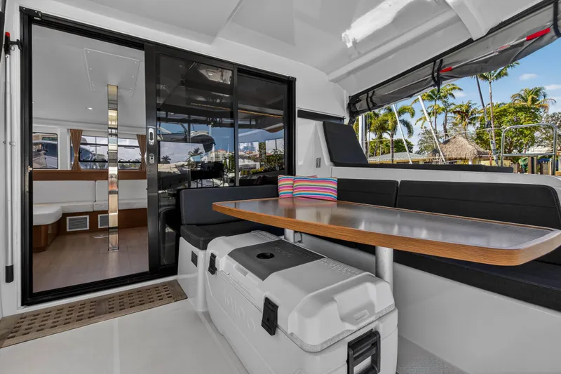 Slide: The Image of 2019 Lagoon 42 yacht interior with seating, table, and tropical view. - 17