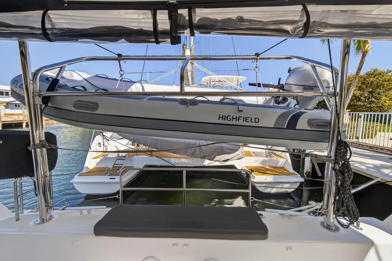 Slide: The Image of 2019 Lagoon 42 catamaran with Highfield dinghy on davits, docked in sunny marina. - 27
