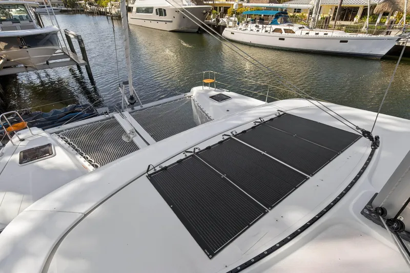 Slide: The Image of 2019 Lagoon 42 catamaran docked, featuring solar panels and spacious deck. - 38