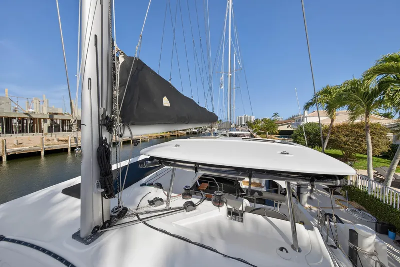 Slide: The Image of 2019 Lagoon 42 catamaran docked by palm trees and waterfront homes. - 40