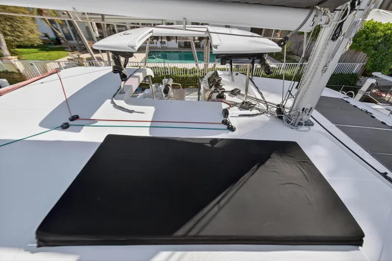 Slide: The Image of Rooftop view of 2019 Lagoon 42 catamaran with sunbathing area and sailing equipment. - 44