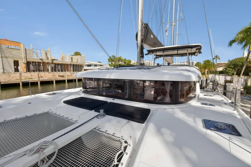 Slide: The Image of 2019 Lagoon 42 catamaran docked near waterfront construction site. - 49