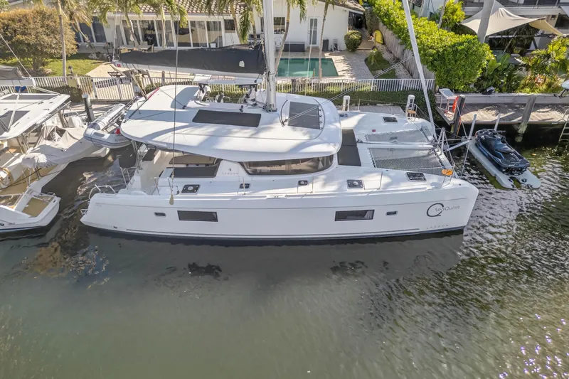 Slide: The Image of 2019 Lagoon 42 catamaran docked by waterfront home, aerial view. - 6