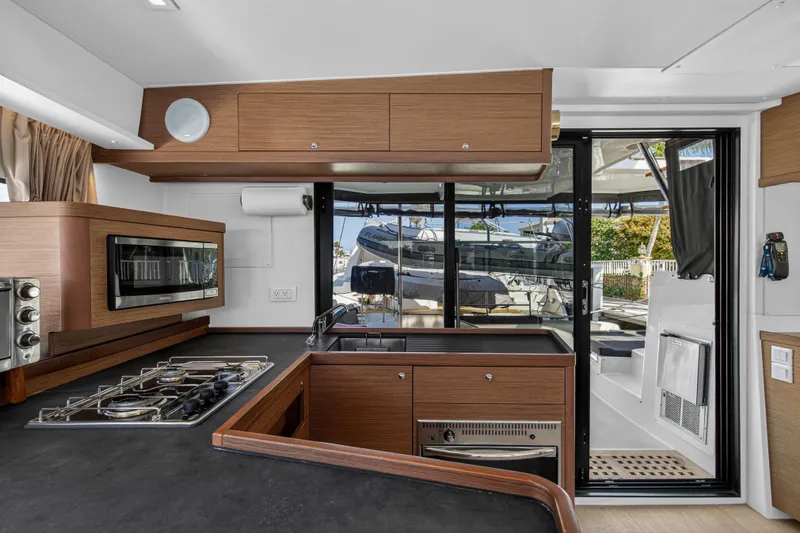 Slide: The Image of Modern kitchen interior of 2019 Lagoon 42 yacht with stove, oven, and outdoor view. - 65