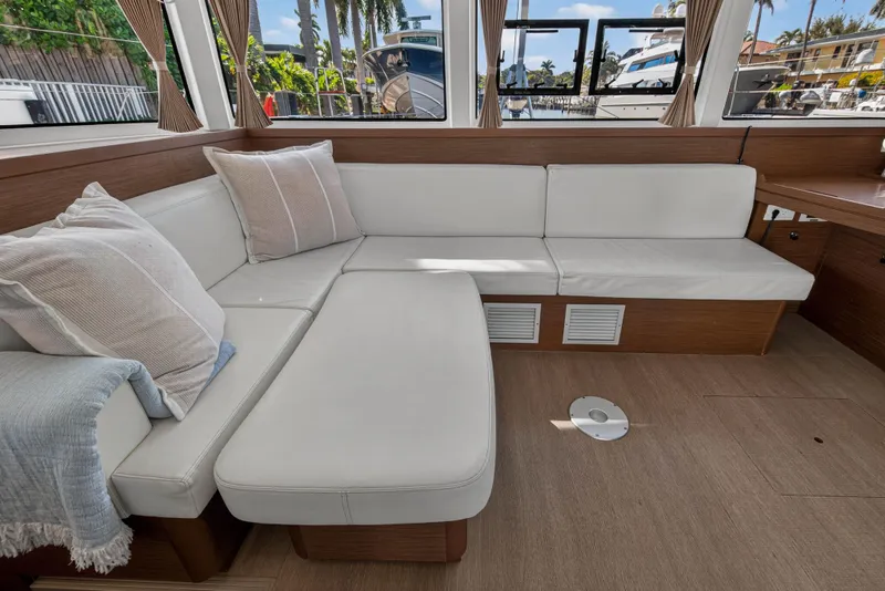 Slide: The Image of Luxurious interior of 2019 Lagoon 42 yacht with white seating and scenic windows. - 67