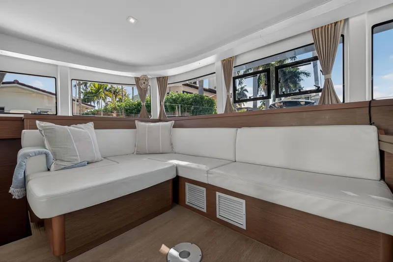 Slide: The Image of Luxurious interior of 2019 Lagoon 42 catamaran with white seating and large windows. - 68