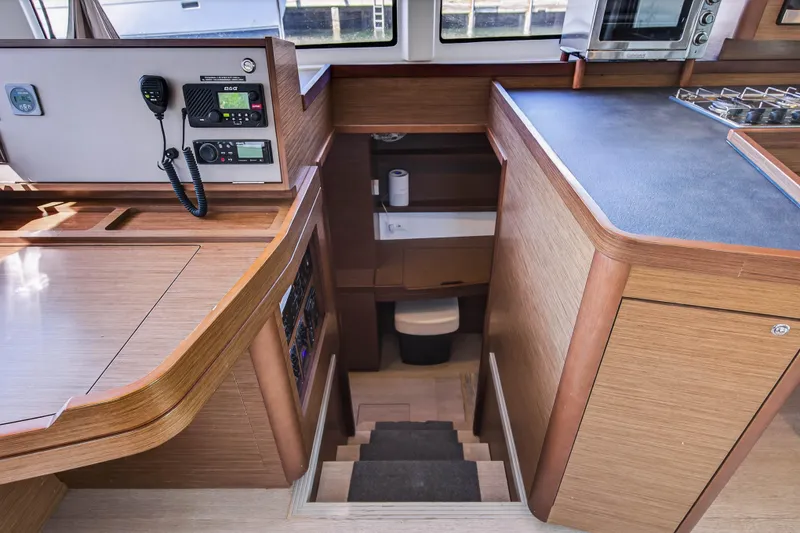 Slide: The Image of 2019 Lagoon 42 yacht interior with navigation equipment and wooden cabinetry. - 74