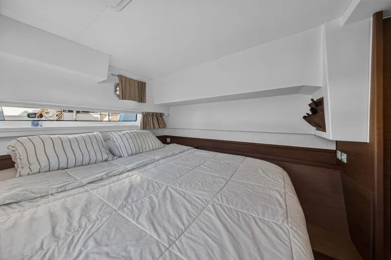 Slide: The Image of Interior cabin of 2019 Lagoon 42 catamaran with cozy bed and striped pillows. - 82