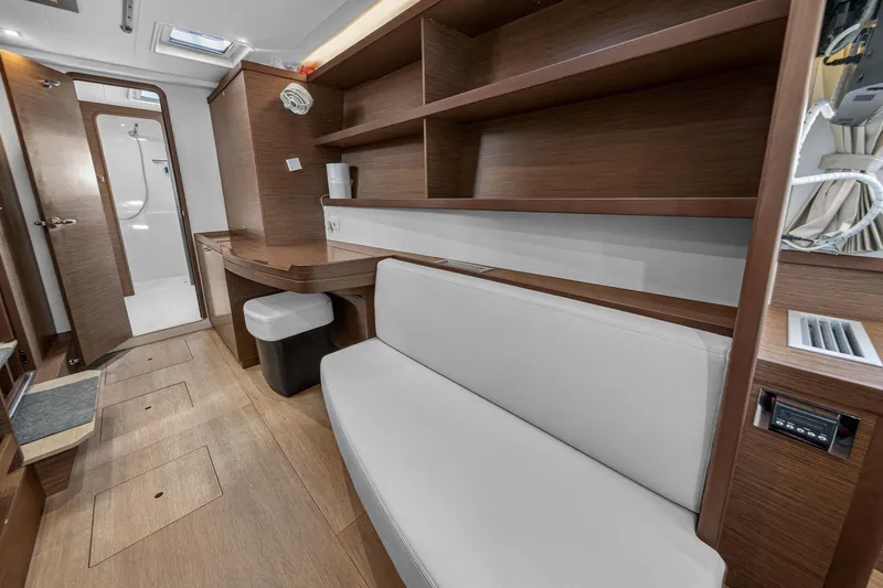 Slide: The Image of Interior of 2019 Lagoon 42 catamaran with wooden shelves, seating, and bathroom entrance. - 84