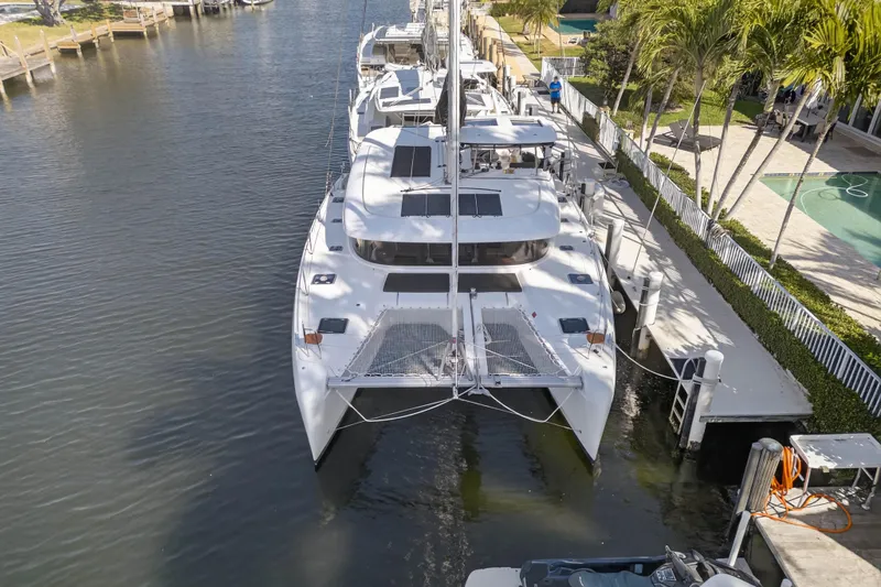 Slide: The Image of 2019 Lagoon 42 catamaran docked in a serene marina setting. - 9