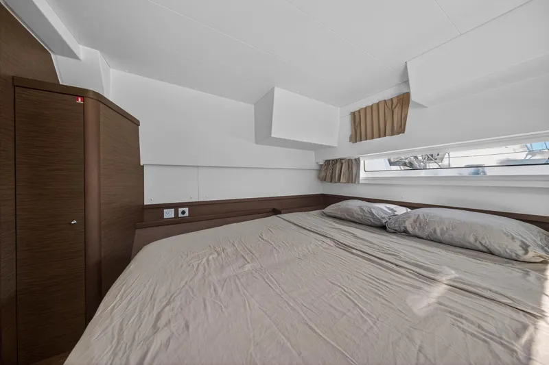 Slide: The Image of Interior cabin of 2019 Lagoon 42 catamaran with bed and window view. - 94