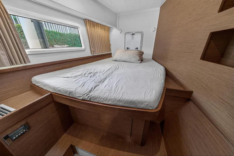 Slide: The Image of Cozy cabin interior of 2019 Lagoon 42 catamaran with wooden finish and comfortable bed. - 99