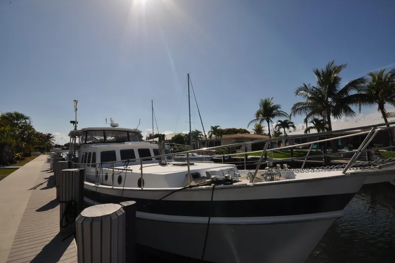 The Image of 1982 Custom Virpack Steelhull yacht docked under sunny skies with palm trees. - 0