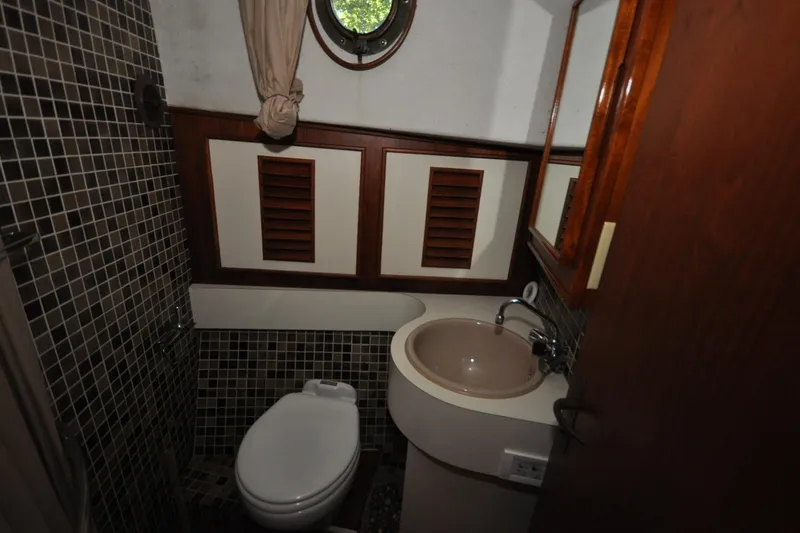 Slide: The Image of Compact bathroom in 1982 Custom Virpack Steelhull boat with porthole and tiled walls. - 12