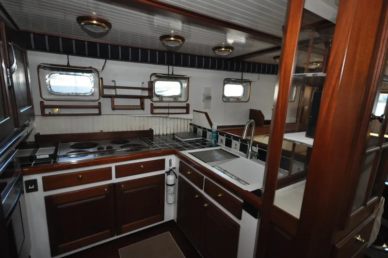 Slide: The Image of Interior of 1982 Custom Virpack Steelhull yacht kitchen with wooden cabinets and modern appliances. - 14