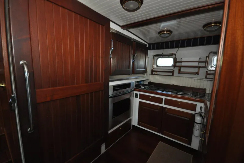 Slide: The Image of Interior of 1982 Custom Virpack Steelhull yacht kitchen with wooden cabinets and modern appliances. - 17