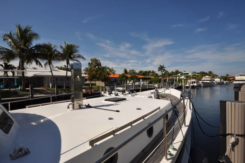 Slide: The Image of Custom 1982 Virpack Steelhull yacht docked in a sunny marina with palm trees. - 27