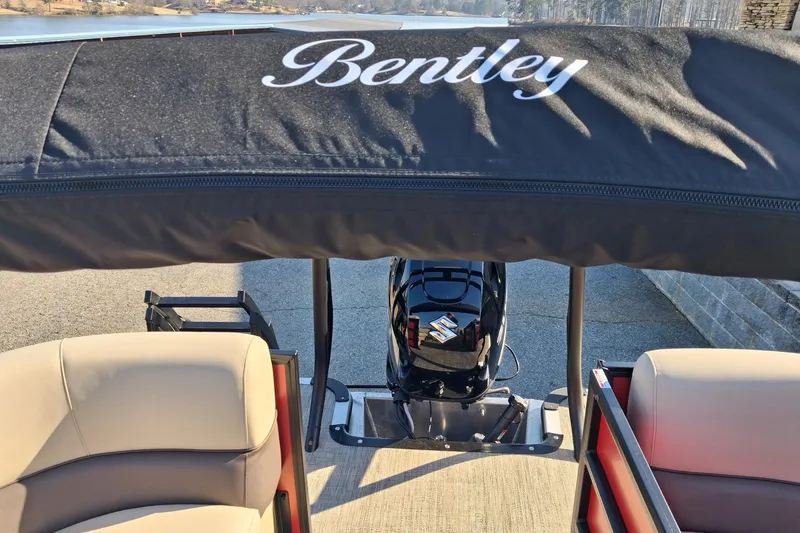 Slide: The Image of 2026 Bentley Pontoons Legacy 240 Navigator with canopy and seating, docked by the water. - 6