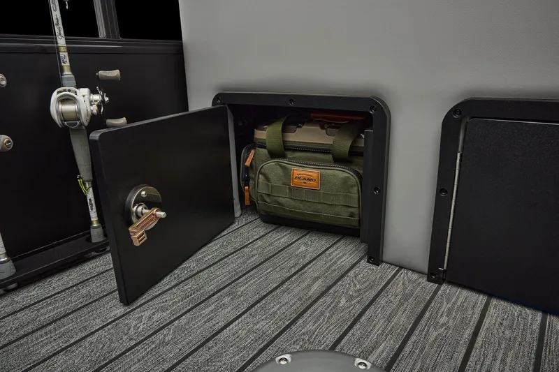 Slide: The Image of Manufacturer Provided Image: 2026 Ranger 220FC boat storage compartment with fishing gear and secure lock. - 44