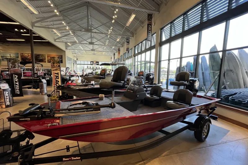 Slide: The Image of 2026 Tracker Bass Tracker Classic XL boat displayed in a showroom with large windows. - 2